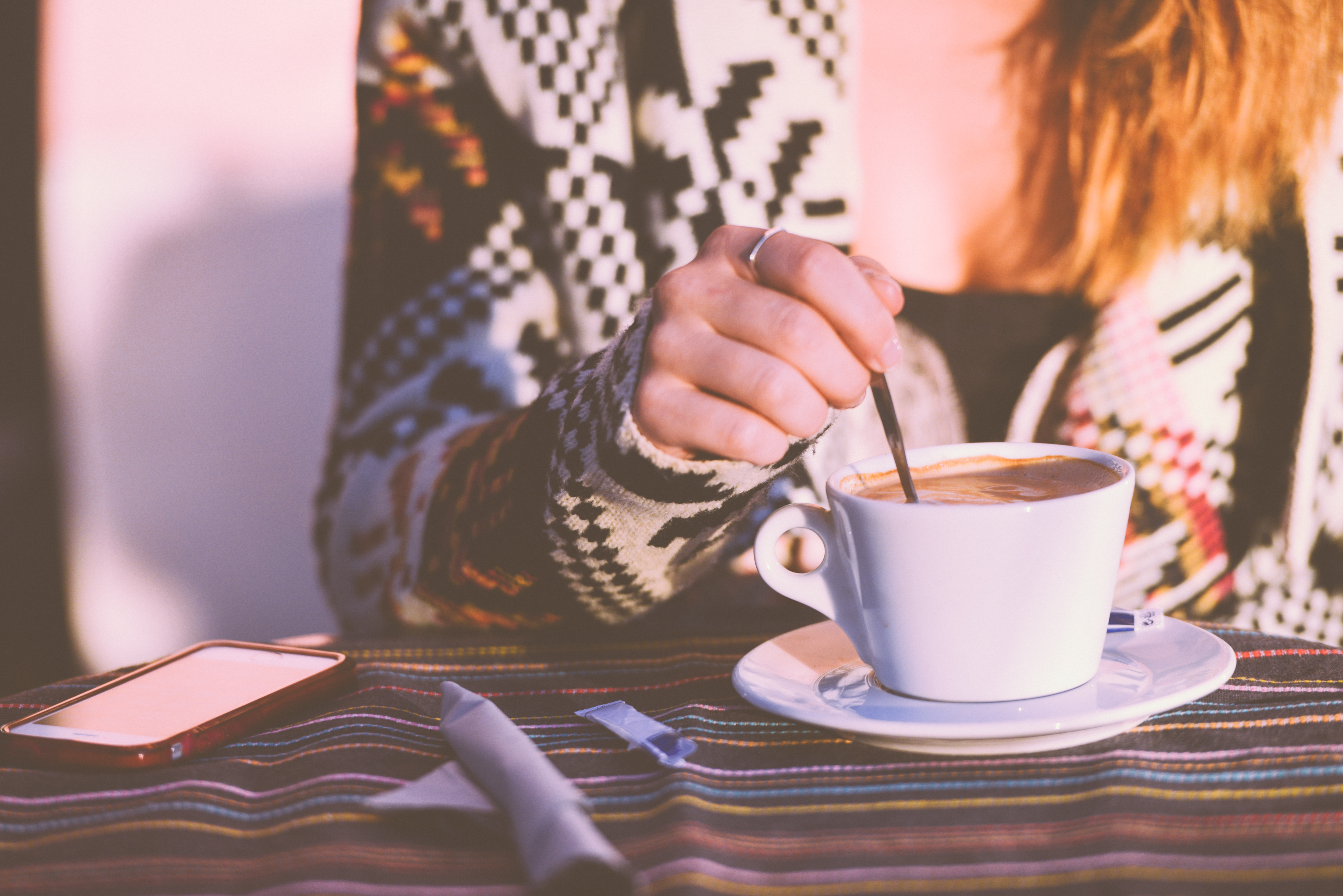 Girl Stirring Early Morning Coffee In A Cafe